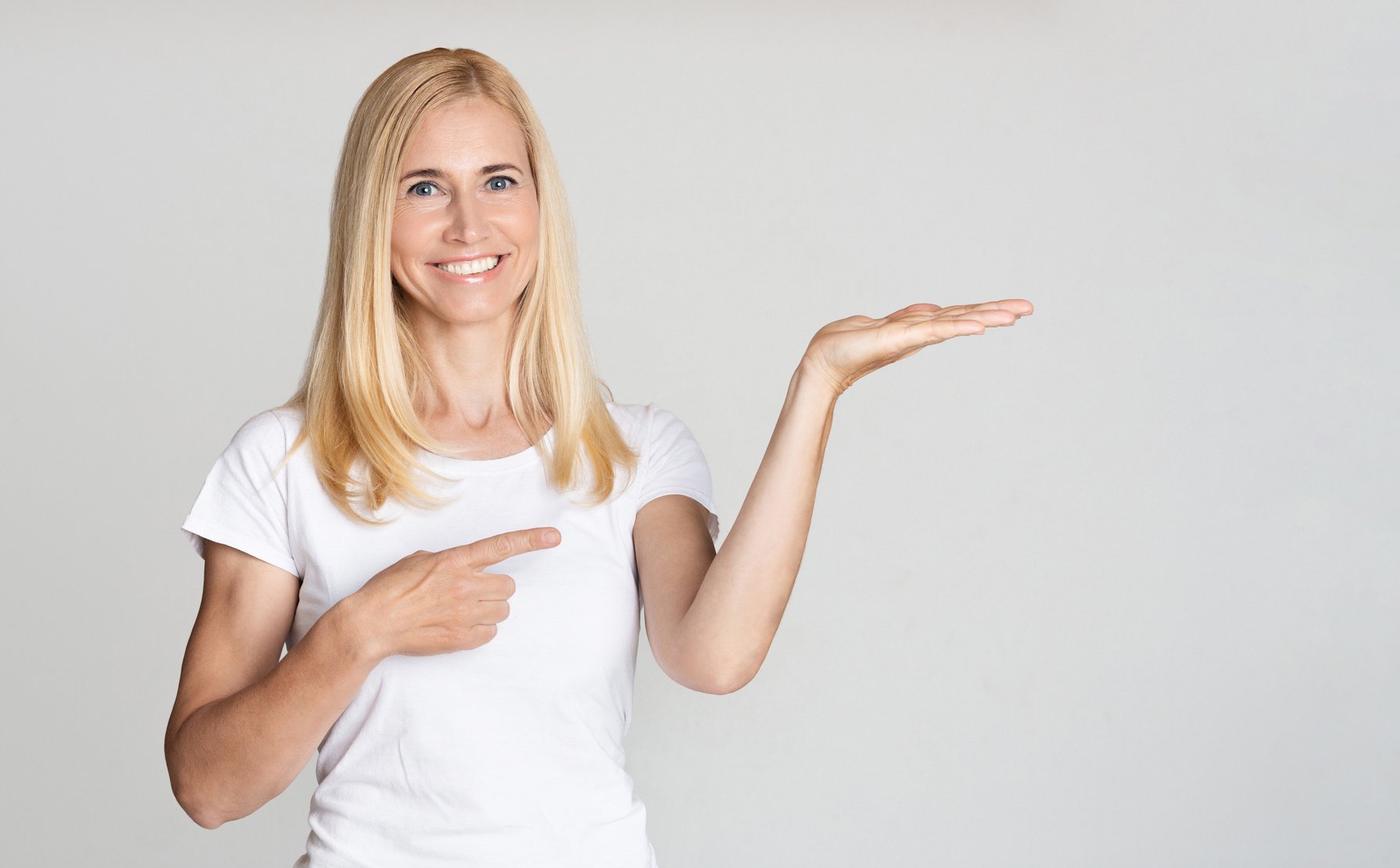 Middle aged woman presenting product on palm