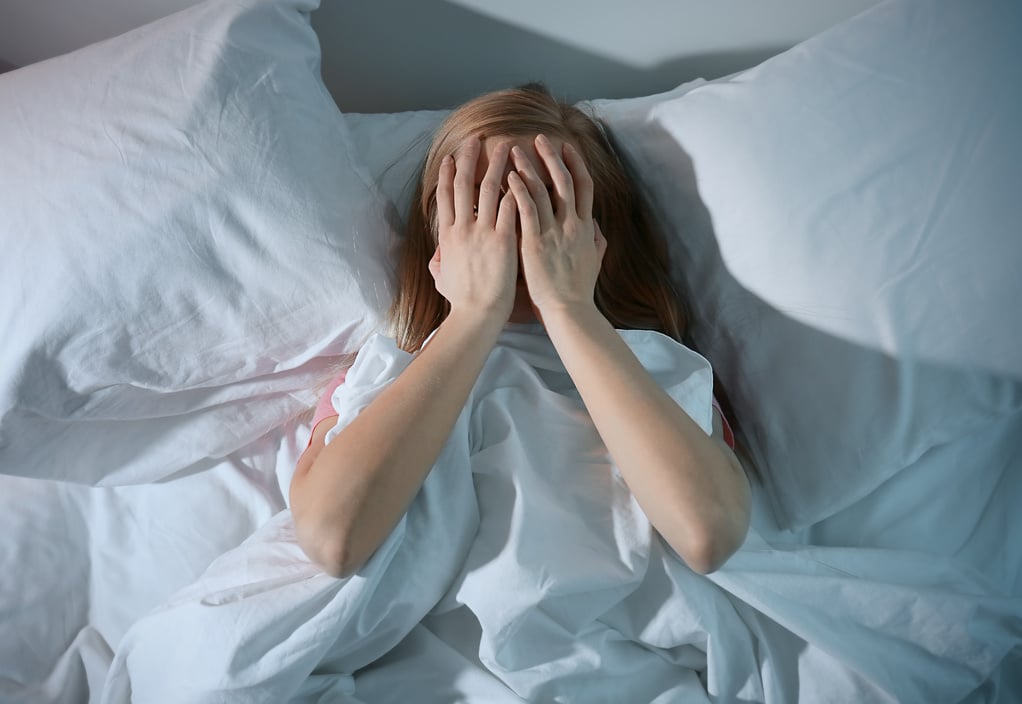 Scared Woman Lying in Bed at Home